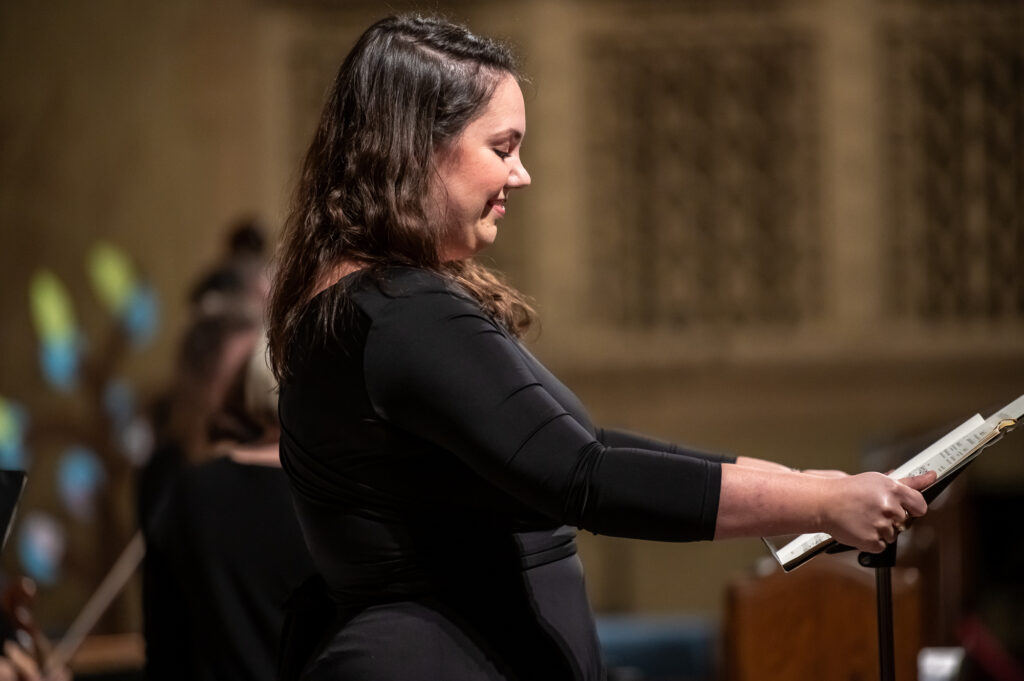 Soprano Myriam Leblanc singing front-stage, holding her music stand