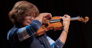 Gwen Hoebig playing the violin on a black background