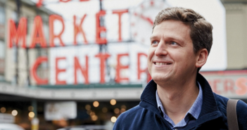 Portrait of James Ethnes in front of red neon Market sign