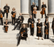 I Musici de Montréal - Chamber Orchestra standing on beige stairs