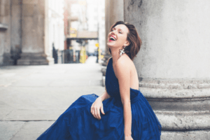 Mary Bevan laughing in a blue dress