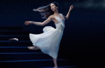 Une ballerine en robe blanche qui danse sur scène sous un ciel étoilé, créant une atmosphère onirique digne d'un conte de fées.